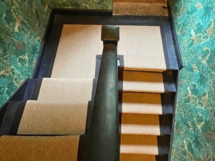 Roger Oats Stairs Carpet - beige carpet on black stairs with green wallpaper