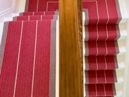 Roger Oats Stairs Carpet - red carpet with white lines down white stairs in modern home.